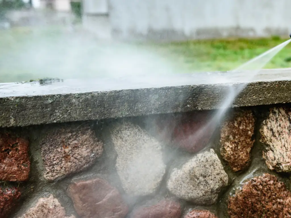 Professional pressure washing of an exterior brick wall on a Moorestown, NJ home — removing algae, moss, and decades of weathering from historic brick and mortar facades.