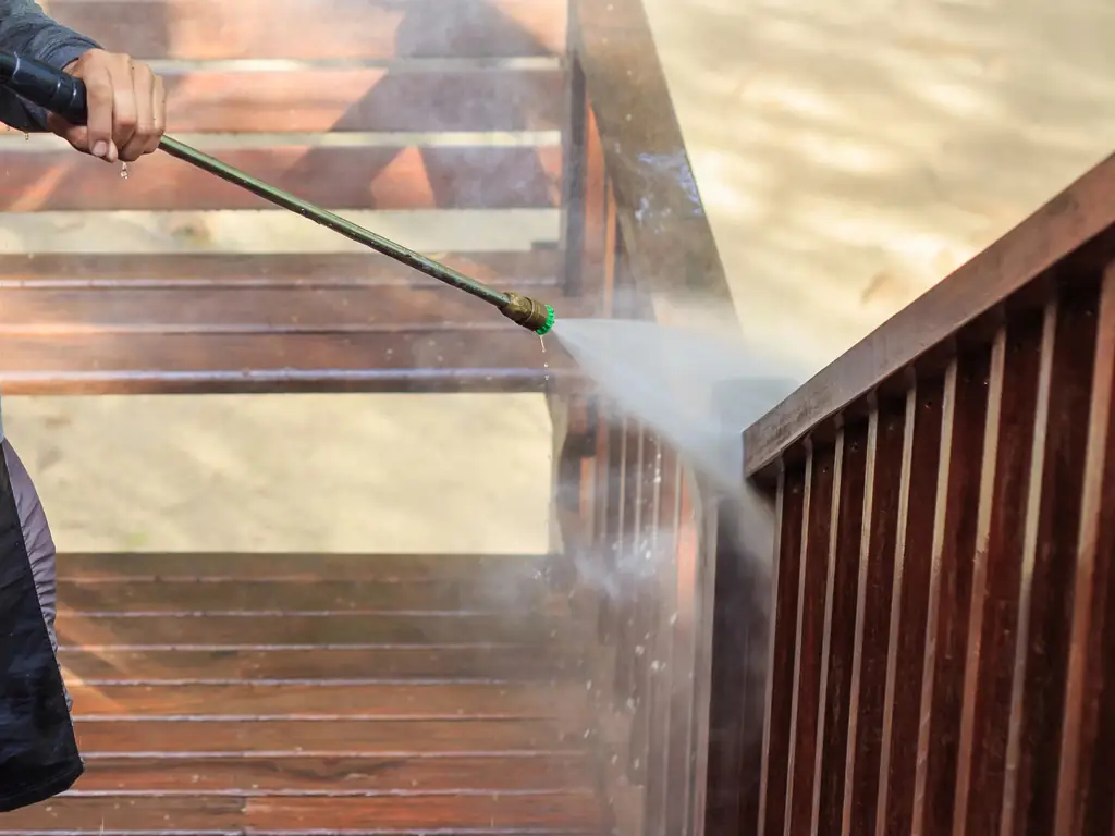 Power washing backyard wood deck stairs and railings on a Williamstown, NJ home — removing mold, mildew, and weathered gray surface from outdoor wood structures.