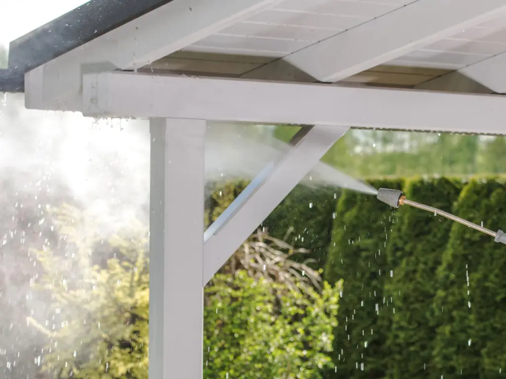 Power washing a white wooden pergola roof at an Avalon, NJ beach property — cleaning salt residue, mildew, and weathering from outdoor wood structures.
