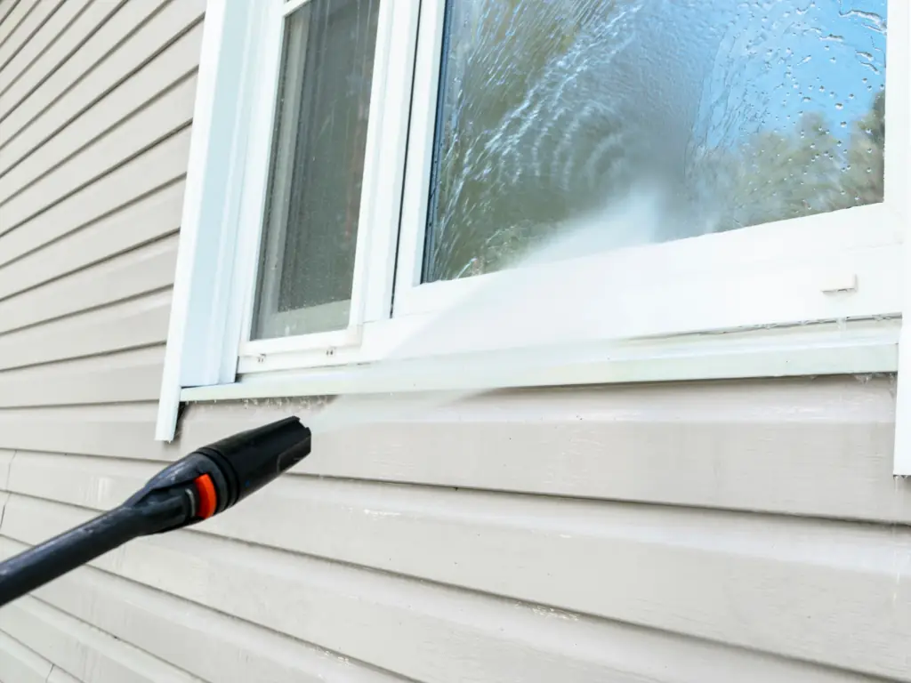 Exterior window pressure washing on a house in Swedesboro, NJ — removing dirt, mineral deposits, and algae from window frames and surrounding trim.